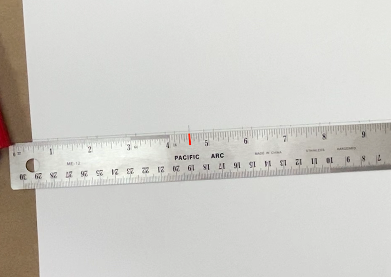Marking the paper at the ruler's four and a half inch mark