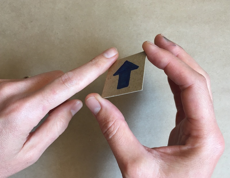 Turning over the square of cardboard