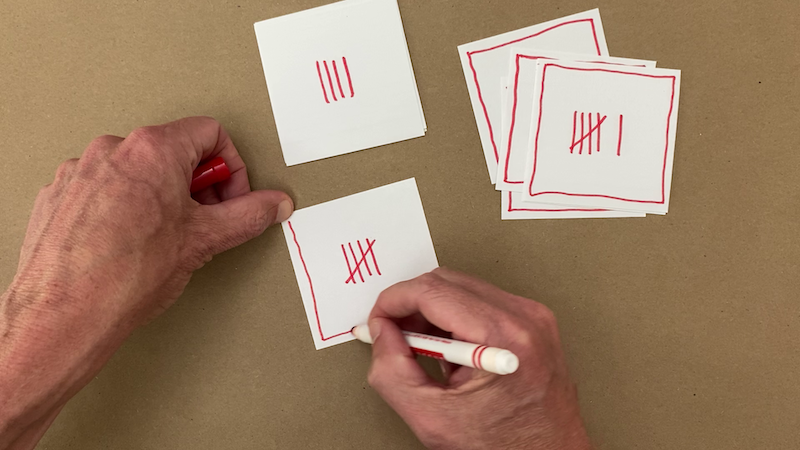 Cards with red tally marks on them indicating the numbers 0 through 10