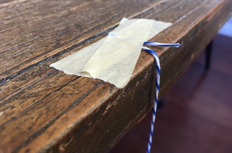 String taped to the side of a table